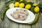 Raw fresh chicken on porcelain plate with lemon and chilli on the wooden background