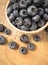 Raw fresh huckleberry in a bowl. Wooden background