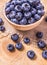 Raw fresh huckleberry in a bowl. Wooden background