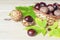 Raw fresh inshell chestnuts in basket with green and yellow leaves on wooden background. traditional dishes for christmas