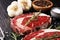 Raw fresh meat Ribeye Steak, seasoning and meat fork on rustic background