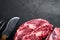 Raw fresh organic top choice meat ribeye steak, on black stone background, top view flat lay, with copy space for text