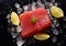 Raw fresh tuna fillet steak slice with lemon on black stone board.Macro.AI generative