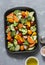 Raw fresh vegetables on a baking sheet. Sweet potato, zucchini, sweet pepper, cherry tomatoes, garlic, broccoli cabbage, olive oil