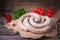 Raw fresh white sausages on a craft paper with vegetables. Weisswurst in a heap. Traditional Bavarian or Munich white sausage made