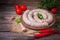 Raw fresh white sausages on a plate with vegetables. Weisswurst in a heap. Traditional Bavarian or Munich white sausage made from