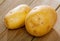 Raw fresh young potatoes at wooden table in home kitchen