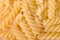 Raw fusilli pasta uncooked closeup. Food background