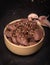 Raw game, beef meat in cubes, in a bowl, on a black background, blackboard, close up. Diced red meat with seasonings.