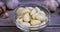 Raw garlic clove peeled in glass bowl on wooden background