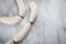 Raw German Bavarian WeiÃŸwurst white sausage chain on marble background