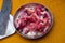 Raw goat red meat pieces with big knife  in a steel plate