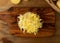 Raw Grated Potato on Wooden Cutting Board Background