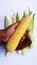 raw green corn pealed in hand  on white background closeup image