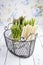 Raw green and white asparagus in a black basket on a rustic wooden shabby chic table