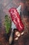 Raw Hanging Tender steak on a butcher knife . Dark background. Top view