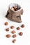 Raw hazelnuts on white background and jute drawstring pouches bag