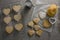 Raw heart shape cookies on baking tray with flour shaker strainer, cookie cutter and wax paper