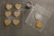 Raw heart shape cookies on baking tray with flour shaker strainer and wax paper