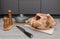 Raw homemade chicken meat on a wooden gray flooring with a knife and a frying pan