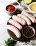 Raw Homemade chicken turkey sausages on a cutting board with different types of sauce