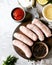 Raw Homemade chicken turkey sausages on a cutting board with different types of sauce