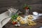 Raw homemade pasta, quail easter eggs in a aluminum cup, green lettuce, tomatoes and flour on wooden table