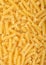 Raw homemade yellow fusilli pasta as texture background