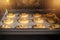 Raw honey biscuits with walnuts in the oven on a baking sheet with parchment paper, ready for baking.