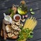 Raw ingredients for cooking pasta with porcini - dried porcini mushrooms, spaghetti, cream, garlic, parsley, basil, olive oil and