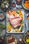 Raw Knuckle eisbein roast preparation on rustic kitchen table with tools and ingredients