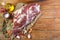 A raw leg of mutton on a bone lies on a piece of burlap , onions, garlic, pepper, salt,rosemary and vegetable oil on a