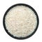 Raw long grain rice in black ceramic bowl isolated on white. Heap of uncooked basmati or jasmine rice