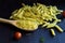 Raw macaroni with fusilli, penne with cherry tomatoes on a black background