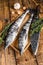 Raw mackerel icefish in a wooden tray. Wooden background. Top view