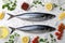 Raw mackerel, peppercorns and tomatoes on white table, flat lay