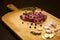 Raw marbled beef on a cutting board. On a black background