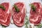 Raw marbled meat steaks on white paper , top view