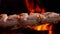 Raw marinated quails on the skewer are roasting on the background the open fire