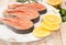 Raw marinated trout fillet on wooden cutting board.