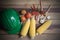 Raw material for making corn salad with green helmet on wooden plate.