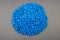 Raw material plastic granules light blue cyan, close-up raw material brown background!