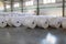 Raw materials warehouse. Many large coils of finished propylene hose made of woven thread for making industrial bags