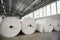 Raw materials warehouse. Many large coils of finished propylene hose made of woven thread for making industrial bags.