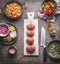 Raw Meat balls on white cutting board on kitchen table background with knife , rice pot and salad dish , cooking preparation , top