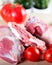 Raw meat beef slices on a wooden chopping board with fresh organic vegetables, onion, garlic, spices, peppercorn, rosemary, sea sa