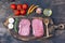 Raw meat beef steak organic fresh ingredient on wooden board table background in kitchen with rosemary, salt, garlic, tomato,