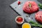 Raw meat beef steaks on black slate board, spices and ingredient