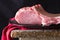 Raw meat on black plate and red towel. Clasic still life