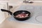 Raw Meat Cooking in Frying Pan on Stove Top